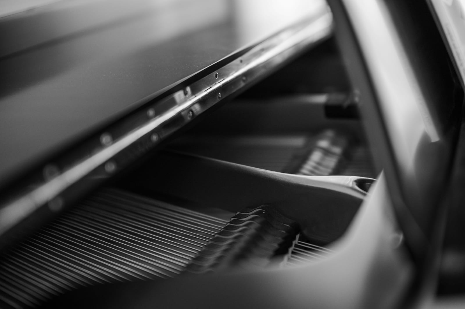 The keys of a grand piano on a showroom floor.